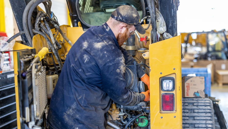 Carter Machinery Technician Working on Equipment with Back Turned